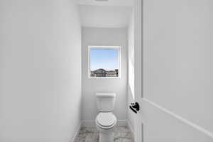 Bathroom with toilet and light marble finish floors