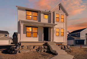 View of front of home featuring a detached garage and covered porch