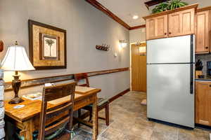 Kitchen featuring freestanding refrigerator and crown molding