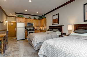 Bedroom with freestanding refrigerator, crown molding, and recessed lighting