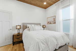 Bedroom with wood ceiling, light wood finished floors, and recessed lighting