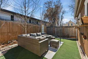 Fenced backyard featuring a patio and an outdoor living space with a fire pit