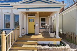 Entrance to property with brick siding and covered porch