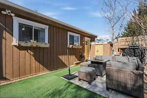 View of patio with a shed and an outdoor living space with a fire pit