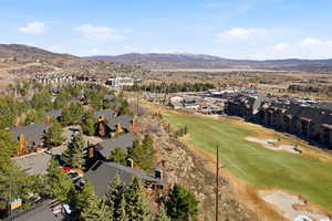 Aerial perspective of suburban area featuring a mountainous background and a golf course