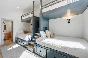 Bedroom with ensuite bath and light wood-style floors