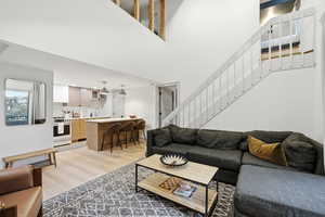 Living area featuring light wood finished floors and a high ceiling
