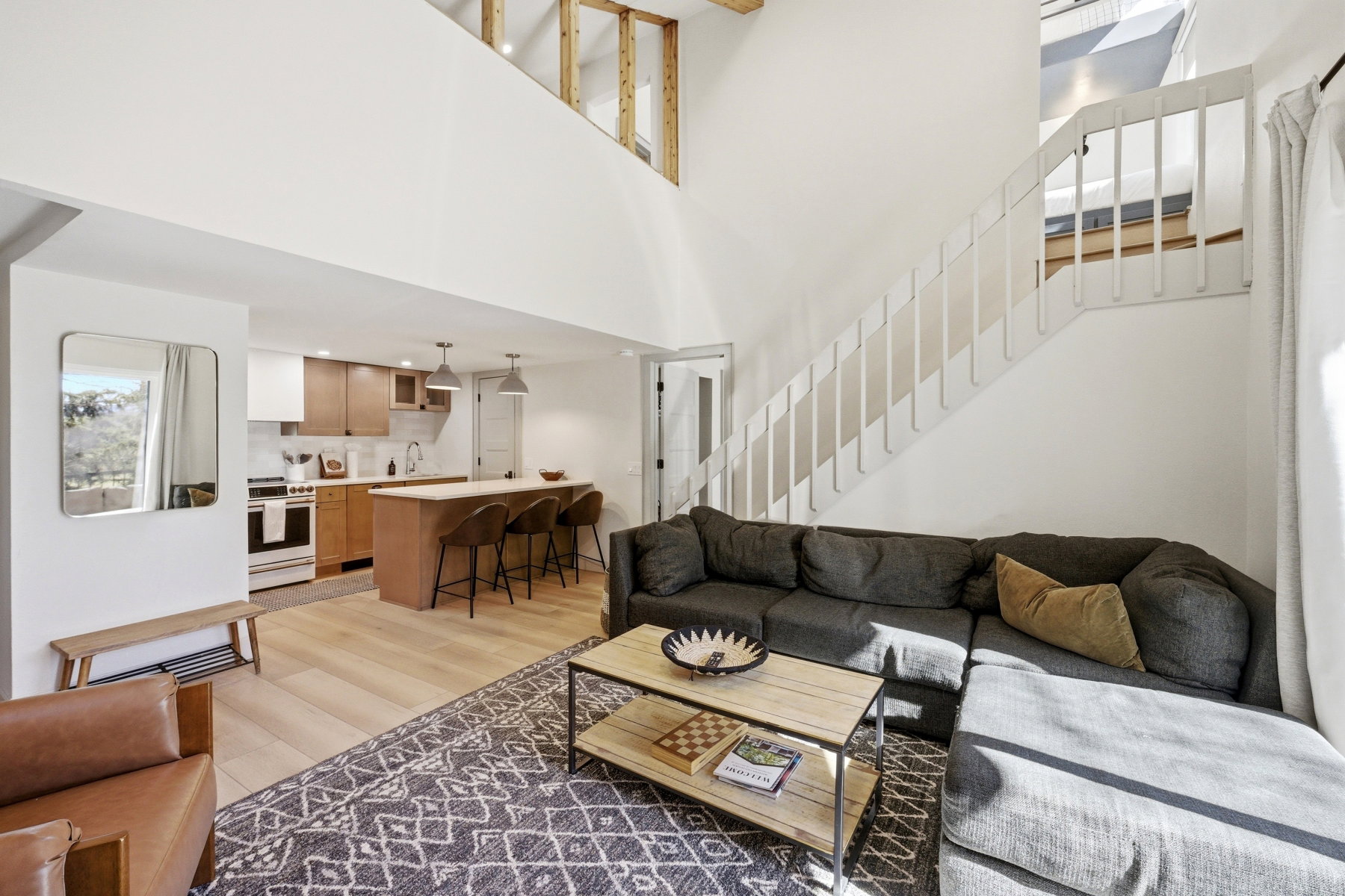 Living area with light wood-style flooring and a high ceiling