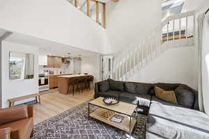 Living area with light wood-style flooring and a high ceiling