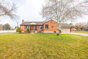 View of front of home featuring a chimney, concrete driveway, and brick siding
