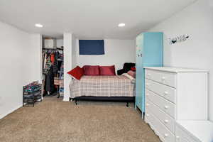 Bedroom with carpet flooring, recessed lighting, and a walk in closet