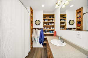 Full bath featuring curtained shower, vanity, dark wood-type flooring, and recessed lighting