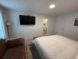 Carpeted bedroom with baseboards and ensuite bathroom