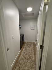 Laundry area with light wood finished floors, washer and clothes dryer, and a raised ceiling