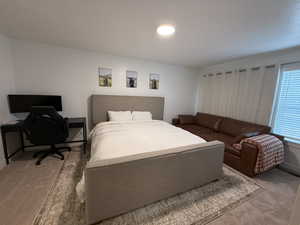Carpeted bedroom featuring a desk