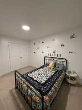 Carpeted bedroom with baseboards and a closet