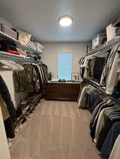 Walk in closet featuring light carpet