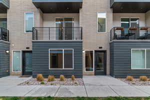 Back of property with a balcony and brick siding
