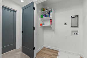 Laundry area with electric dryer hookup, washer hookup, and light wood-type flooring