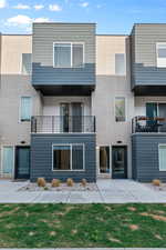 Rear view of property with a balcony and brick siding