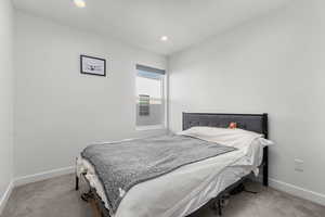 Bedroom with recessed lighting and light carpet