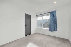 Spare room with light carpet and recessed lighting