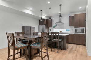 Dining space with light wood finished floors and recessed lighting