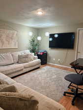Living area with light wood-style flooring and a textured ceiling