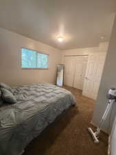 Bedroom with dark carpet and a closet