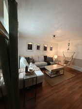 Living room with a textured ceiling and wood finished floors