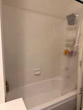 Bathroom featuring shower / bathtub combination with curtain