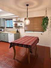 Dining area with dark tile patterned flooring and baseboards