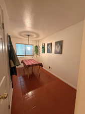 Playroom with a textured ceiling and dark tile patterned flooring