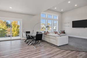 Living room featuring a high ceiling, light wood-style flooring, and recessed lighting