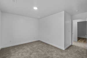 Empty room with carpet floors and baseboards
