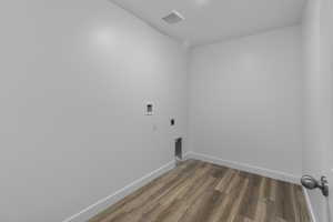Laundry area featuring wood finished floors, electric dryer hookup, and washer hookup