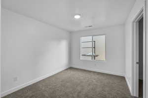 Unfurnished bedroom featuring baseboards and dark colored carpet