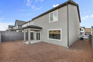 Rear view of property with a patio area, a fenced backyard, and stucco siding