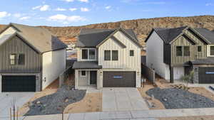 *Photos are of a similar Home*Modern farmhouse with board and batten siding, stone siding, an attached garage, concrete driveway, and a mountain view