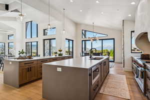 Kitchen with pendant lighting, dark stone countertops, light wood finished floors, stainless steel appliances, and recessed lighting