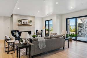 Living room featuring a fireplace, light wood-style flooring, recessed lighting, and a mountain view