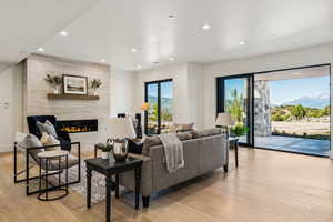 Living area with light wood-style floors, recessed lighting, a fireplace, and a mountain view