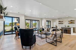 Living area with light wood-style floors, recessed lighting, healthy amount of natural light, and a fireplace