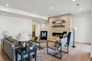 Living area featuring recessed lighting, light wood-style flooring, and a tiled fireplace