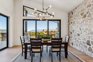 Dining area featuring light wood-style floors, a chandelier, a mountain view, and lofted ceiling