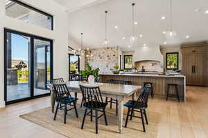 Dining space featuring light wood-style flooring, recessed lighting, high vaulted ceiling, a chandelier, and beam ceiling