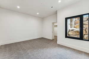 Carpeted spare room featuring recessed lighting and baseboards