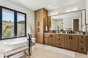 Bathroom with double vanity, a shower stall, a soaking tub, recessed lighting, and light tile patterned flooring