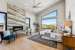 Bedroom featuring wood finished floors, a fireplace, a ceiling fan, and recessed lighting