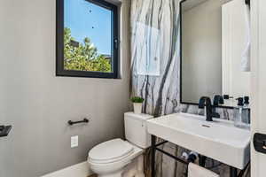 Half bath with toilet and baseboards